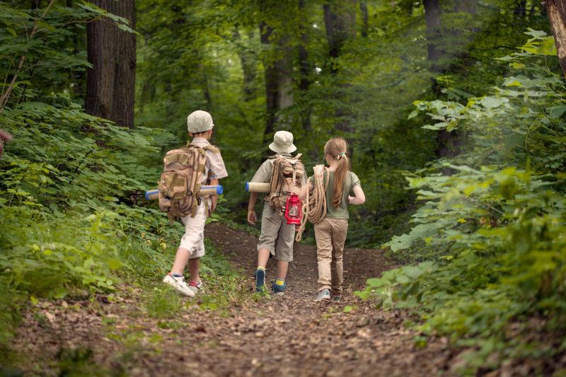 背着包在森林里探险的孩子们