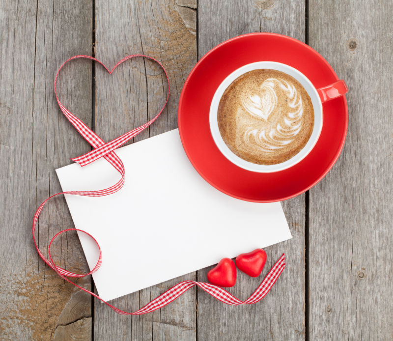木制背景上的空白卡片心形装饰品和一杯咖啡
