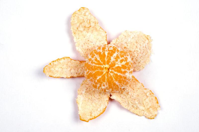 白色背景下的剥开的橘子