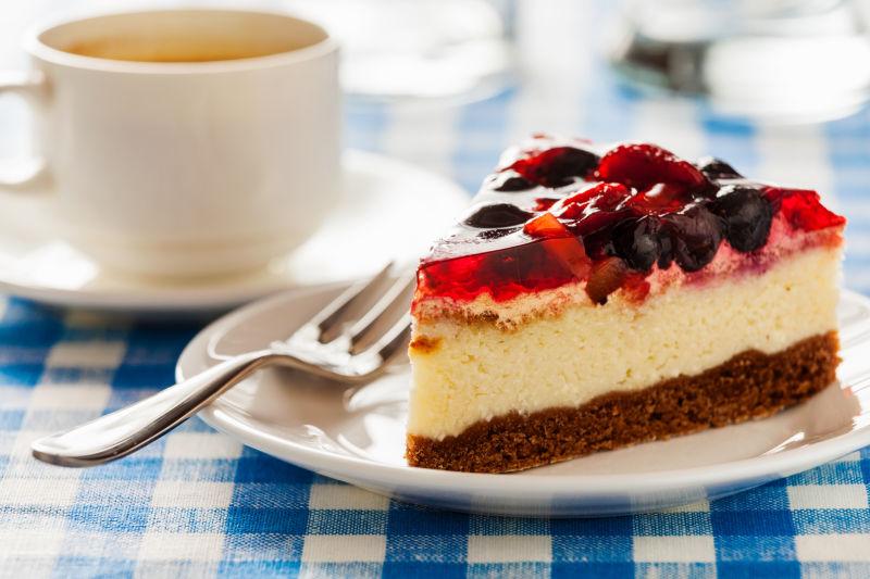 叉子和咖啡杯装在盘子上的蛋糕