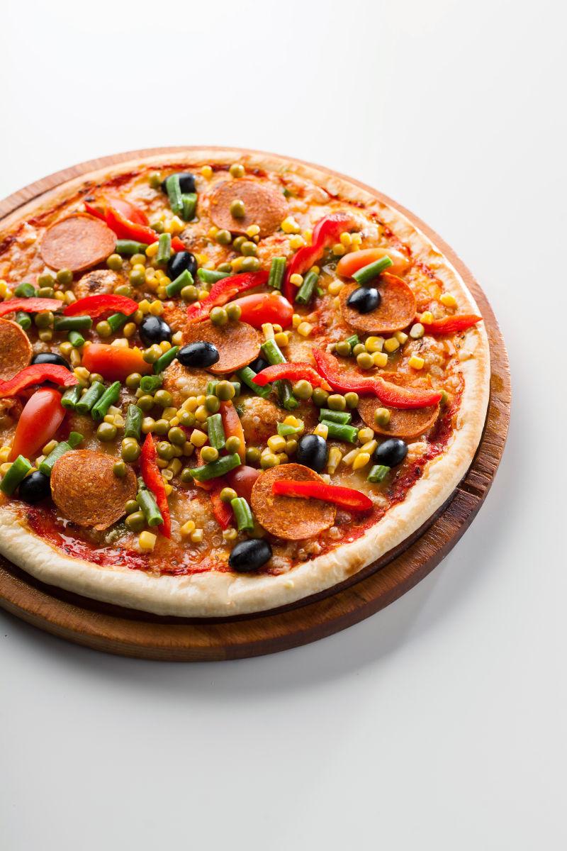 白色背景下的蔬菜腊肠披萨