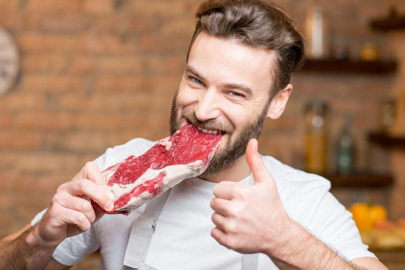 厨房里啃食生牛肉的英俊男子