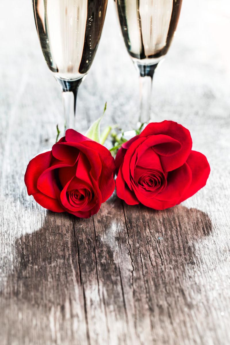 木桌上的高脚杯和玫瑰花