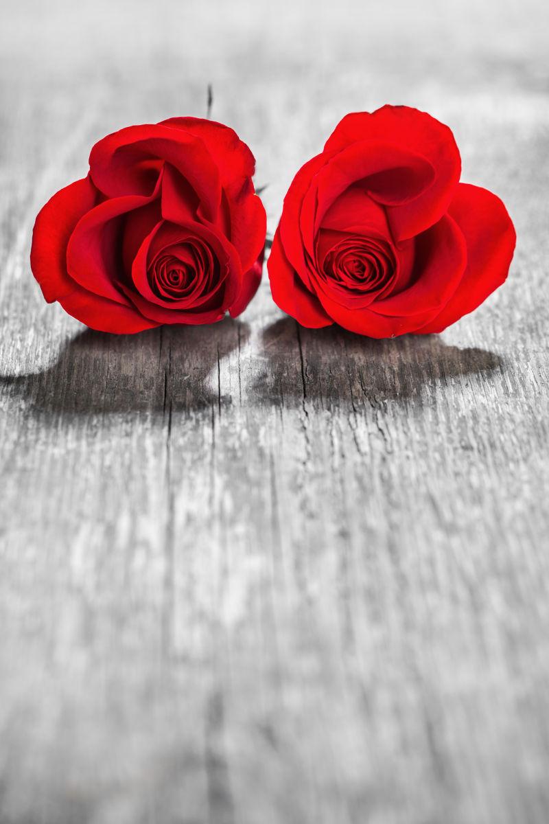 木桌上的两朵红色玫瑰花