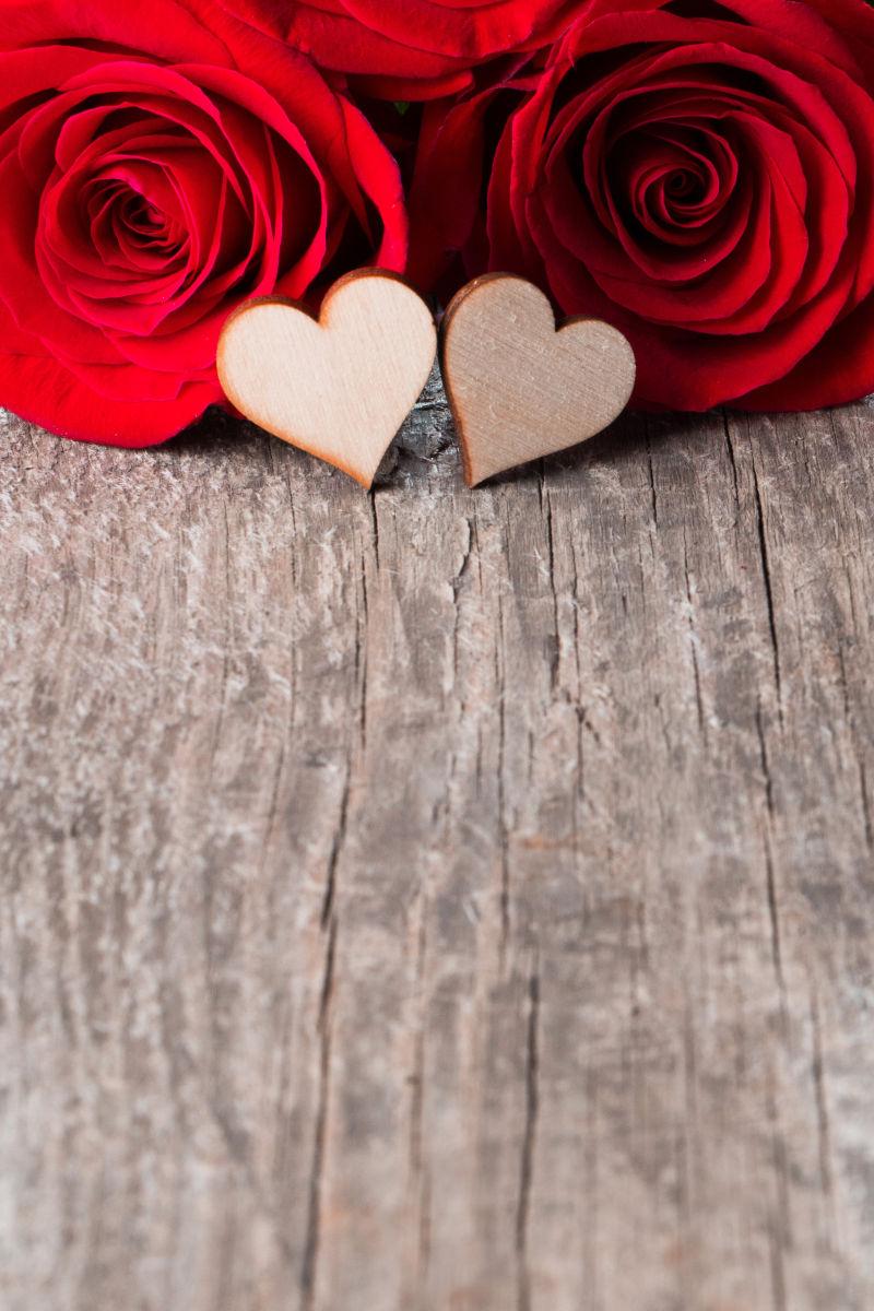 木桌上的红玫瑰和爱心