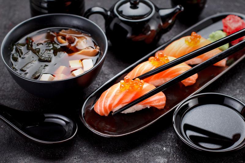 寿司尼日利亚和味噌汤在黑板上一个黑暗的桌子