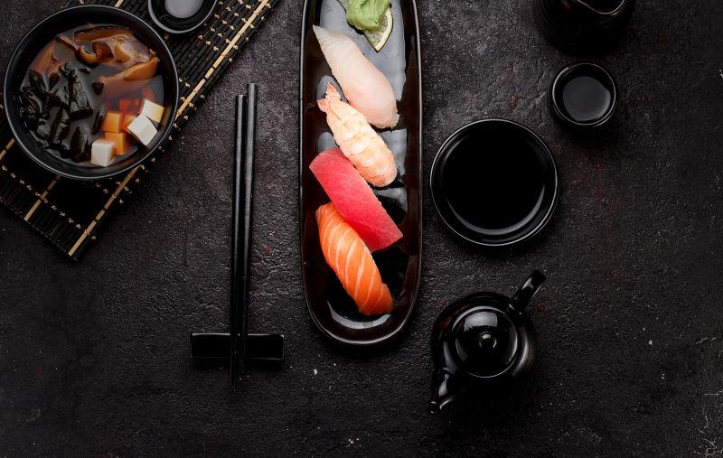 粟实寿司在黑底上放黑盘子和味噌汤