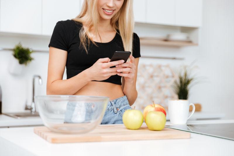 女性在厨房使用智能手机的