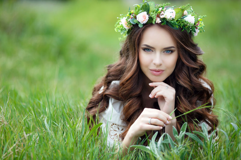草丛里年轻的美女戴着花环
