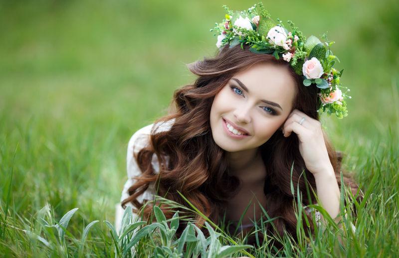 蹲在草丛里微笑的年轻美女