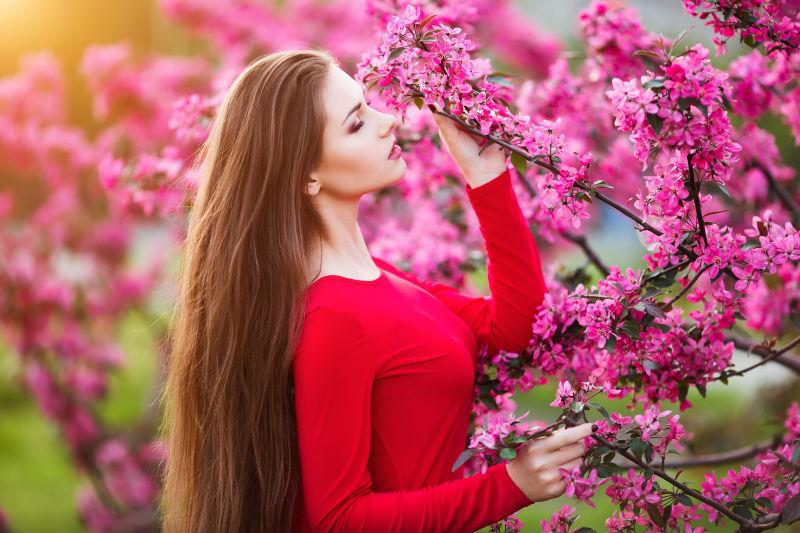 站在满花的树旁的金发女人