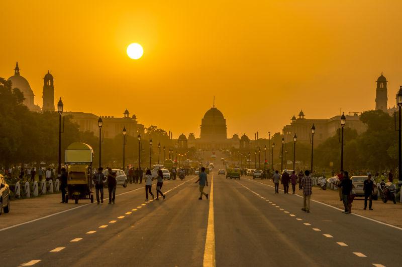 日落时黄色天空下新德里城市街头景观