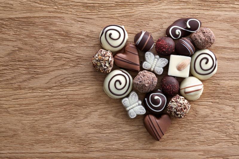 木桌上组成心形的巧克力糖果心糖果