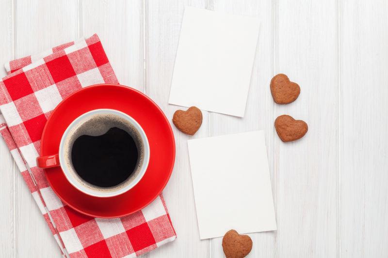 情人节空白贺卡和桌子上的红色咖啡杯