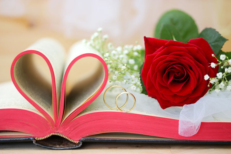 打开的心形书页和玫瑰戒指