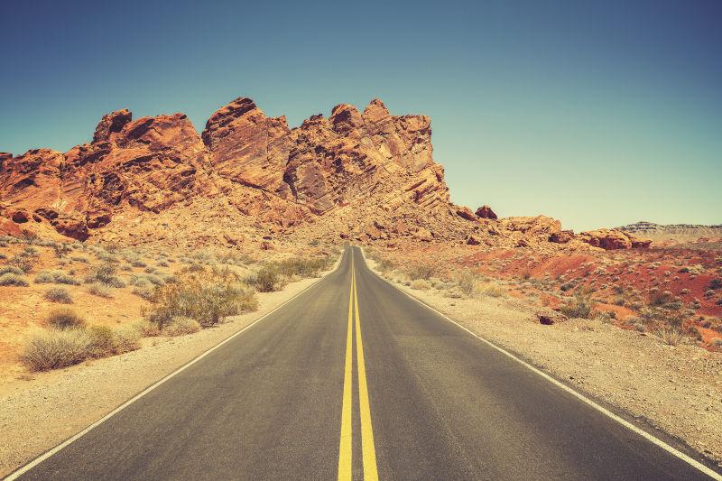 蓝天下的内华达州石漠沙漠的复古风格道路