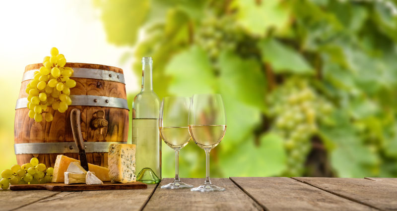 木桌上的木桶旁放着葡萄酒和葡萄
