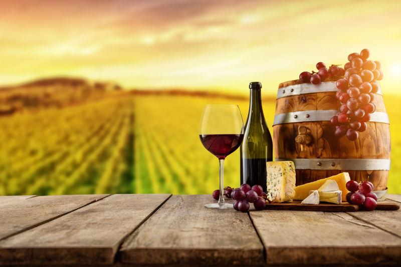 木板上的木桶旁放着红葡萄酒和葡萄