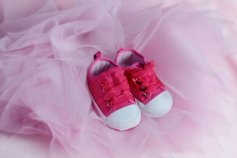 粉色薄纱上的婴儿的鞋子