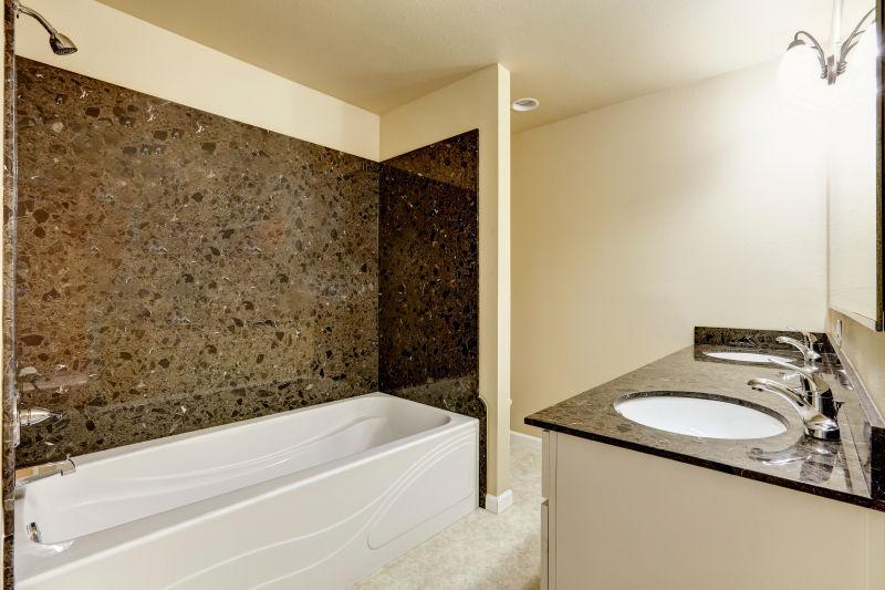 现代浴室黑色花岗岩瓷砖装饰和白色浴缸和水槽