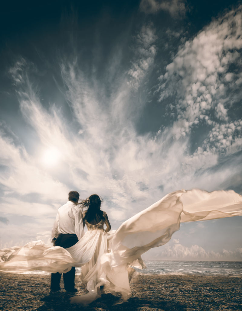 一对新婚夫妇新郎新年站在热带海滩上