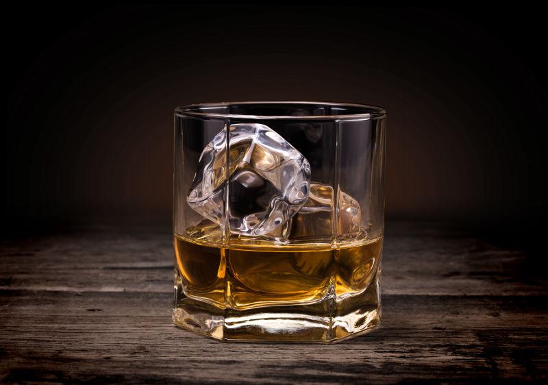黑色的木质背景上的威士忌酒杯