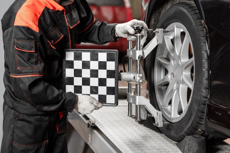 修理工人使用车轮定位装置给汽车定位轮胎
