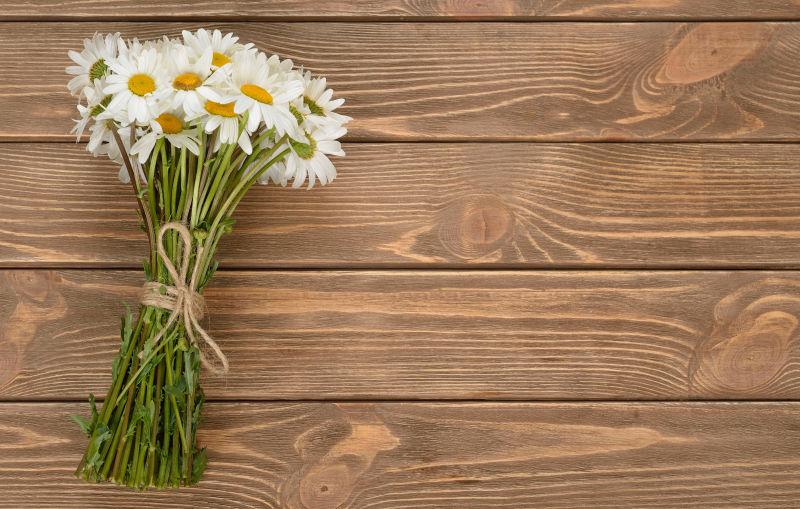 木板上扎好的美丽的白色洋甘菊花束