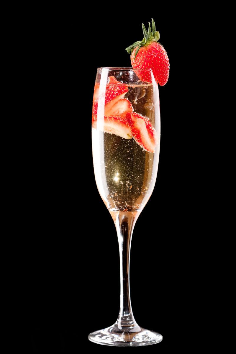 黑色背景上的高脚杯里的草莓与香槟酒