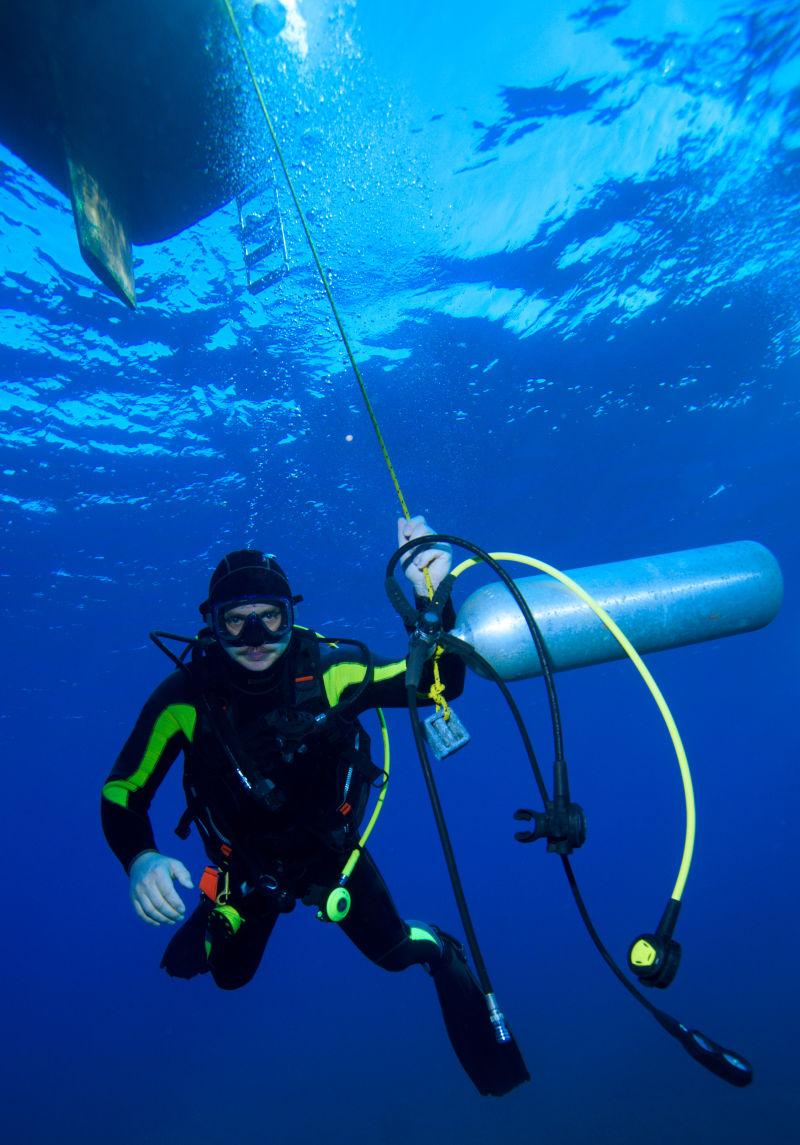 海洋中的潜水员手拿氧气罐