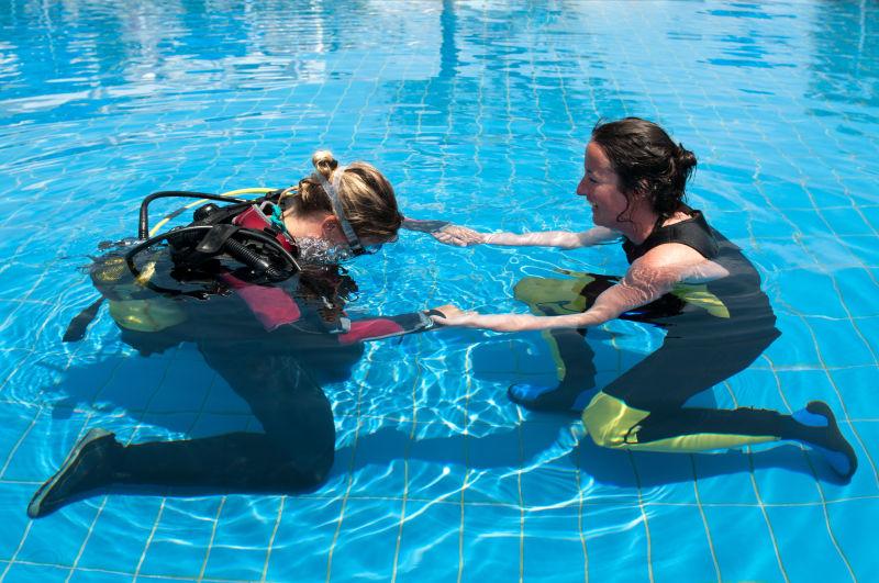 水肺潜水教练和游泳池里的学生