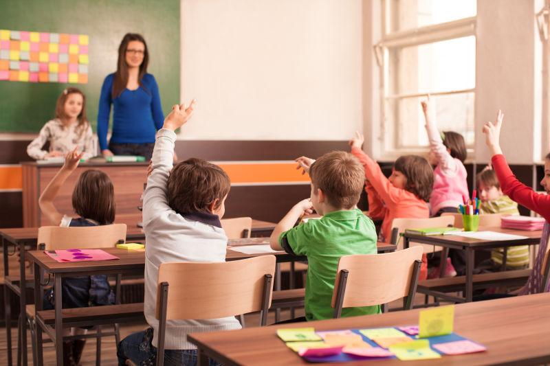 小学的孩子在教室里举起手来