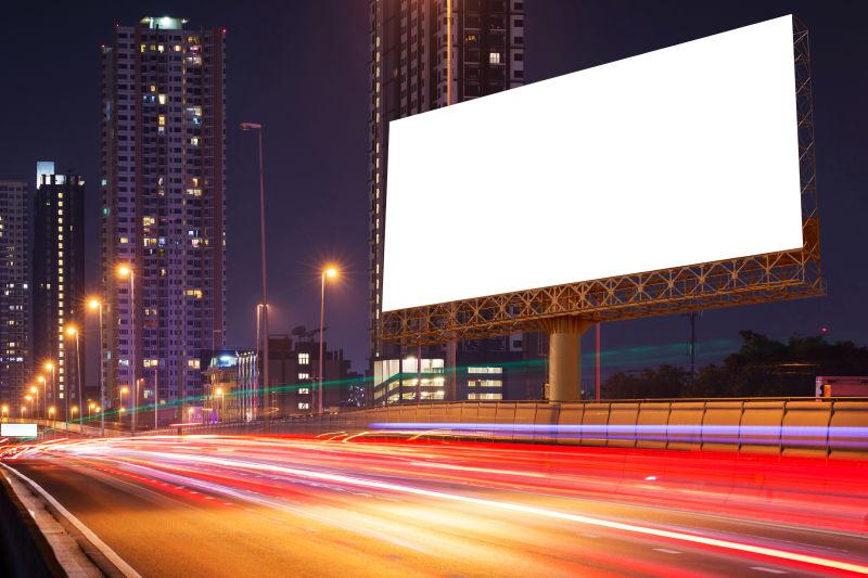 夜晚城市背景下的高速公路上的空白广告牌