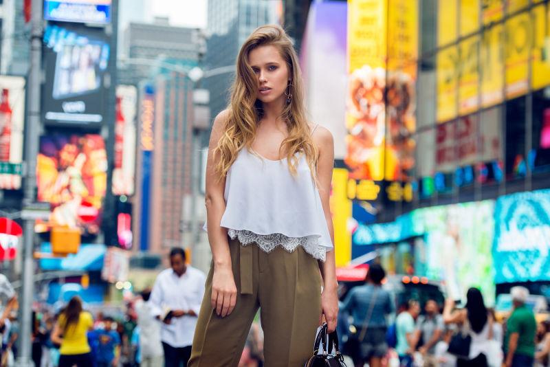 美丽的金发时尚模特女孩站在纽约时代广场