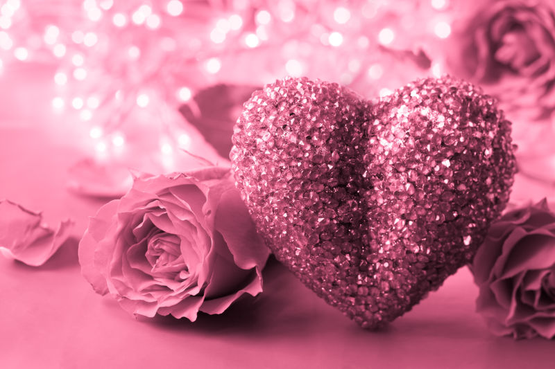 粉色浪漫背景下的玫瑰和爱心