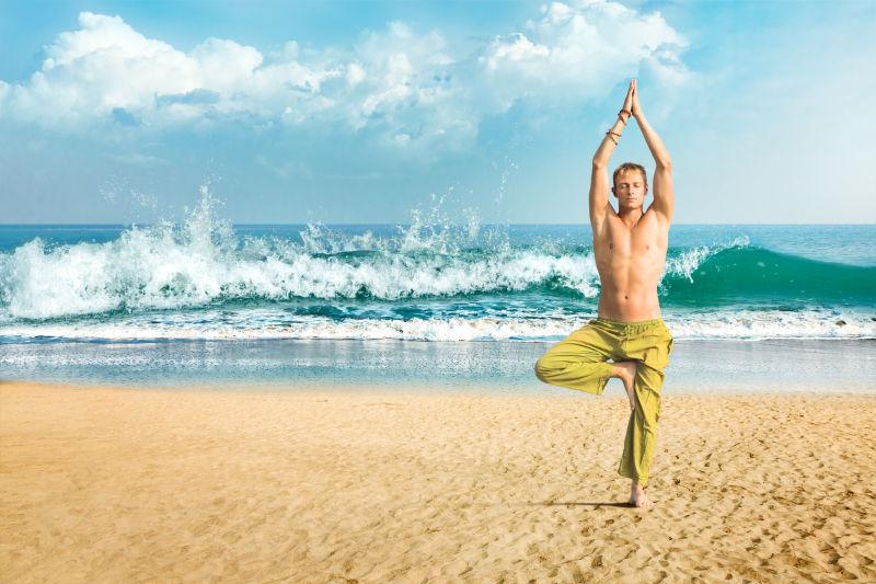 沙滩上正在练瑜伽的男人