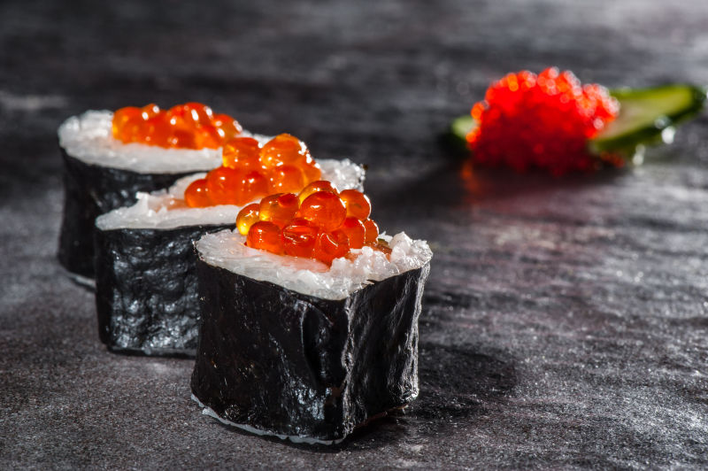 黑色桌面上的鱼子酱寿司