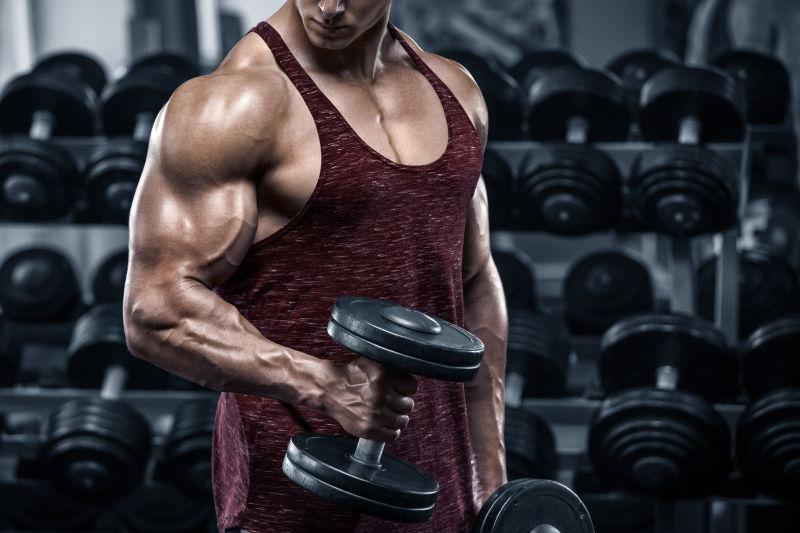 肌肉健壮的人在健身房用哑铃锻炼
