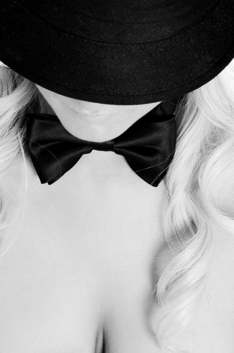 性感的金发女人戴黑色帽子和蝴蝶领结