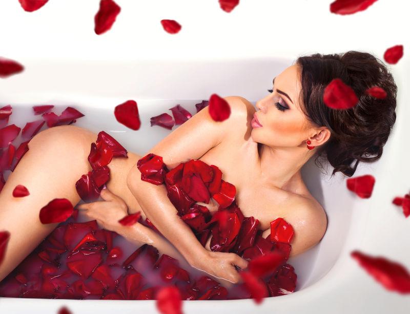 美女躺在放满玫瑰花瓣的浴缸里