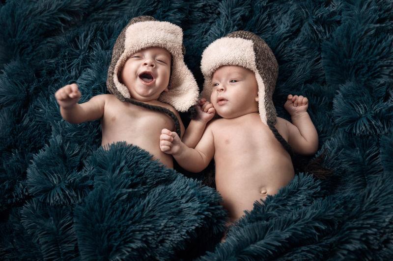 躺在床上玩耍的两个双胞胎婴儿