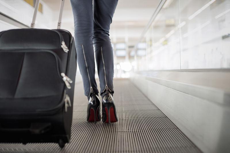 机场里带手提箱坐电梯的女人