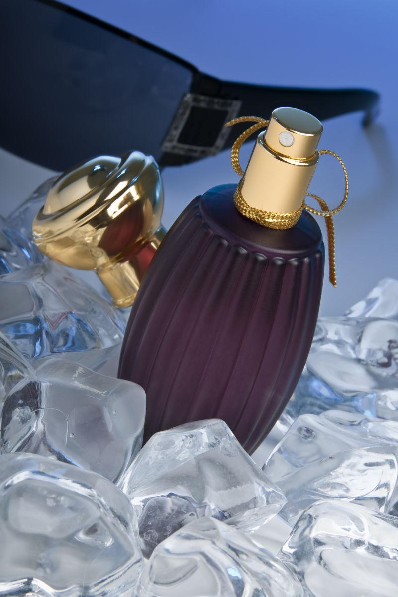 紫色的香水瓶躺在冰上