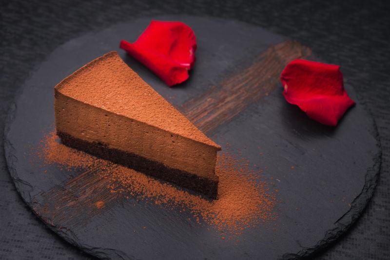 红玫瑰花瓣巧克力蛋糕在石板岩上
