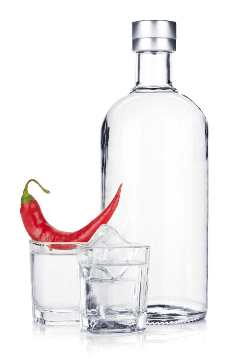 白色背景上的酒瓶酒杯和红辣椒