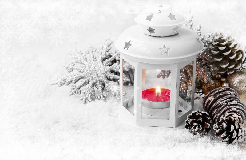 冬季圣诞雪地里的燃烧的蜡烛和白色圣诞灯笼