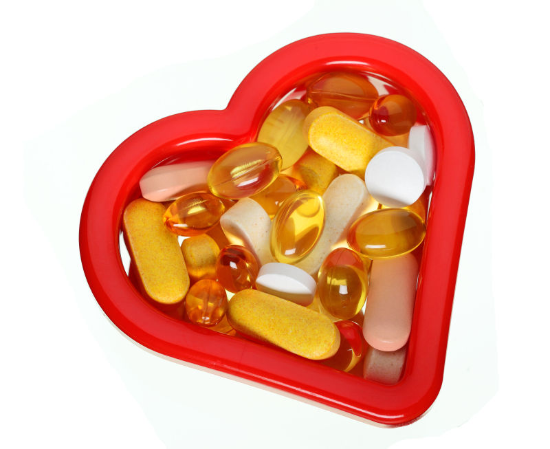 红色爱心盒子里的各种维生素补充剂