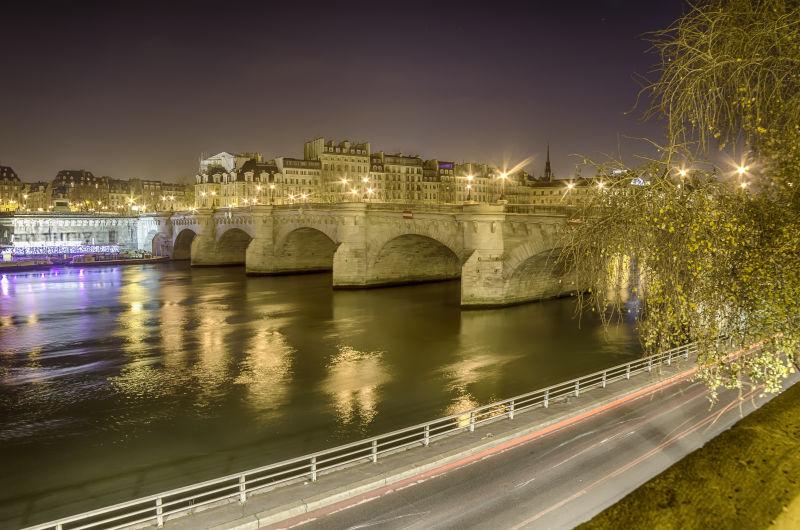 夜幕时分灯火辉煌的法国巴黎塞纳河上的桥