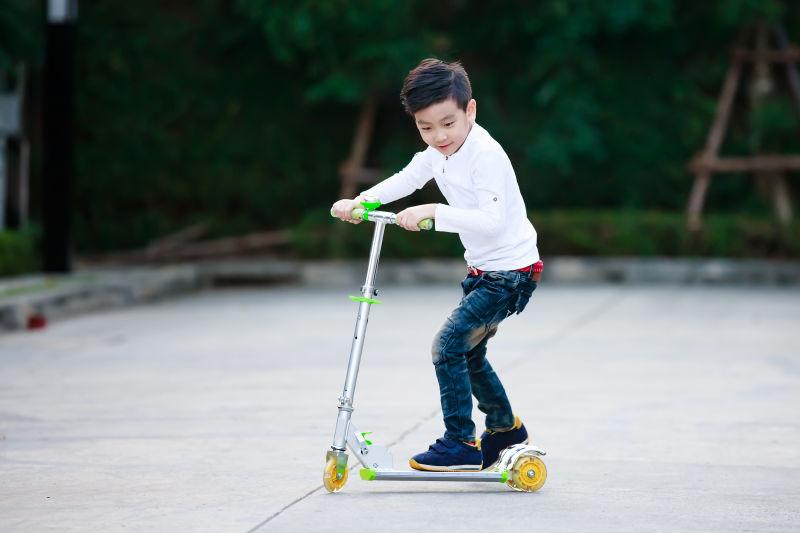 亚洲小男孩玩滑板车