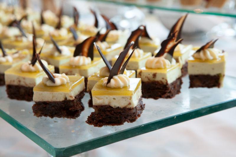 玻璃桌上的美味可口的黄色和巧克力小蛋糕